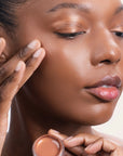 Model applying Bouncy Mousse Multi-Use Pigment product shade Bronze Bliss.