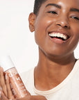 Model holding Illuminating Moisture Mist product shade Bronze Glow.