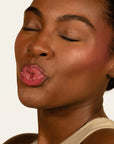 Model wearing Glowify Juicy Plumping Lip Gloss product shade Watermelon Pucker.