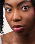 Model wearing Glowify Sheer Silk Lip Oil product shade Silk Berry.