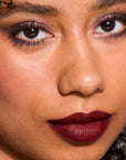 Model wearing LipSense Cream product shade Burgundy Plum.