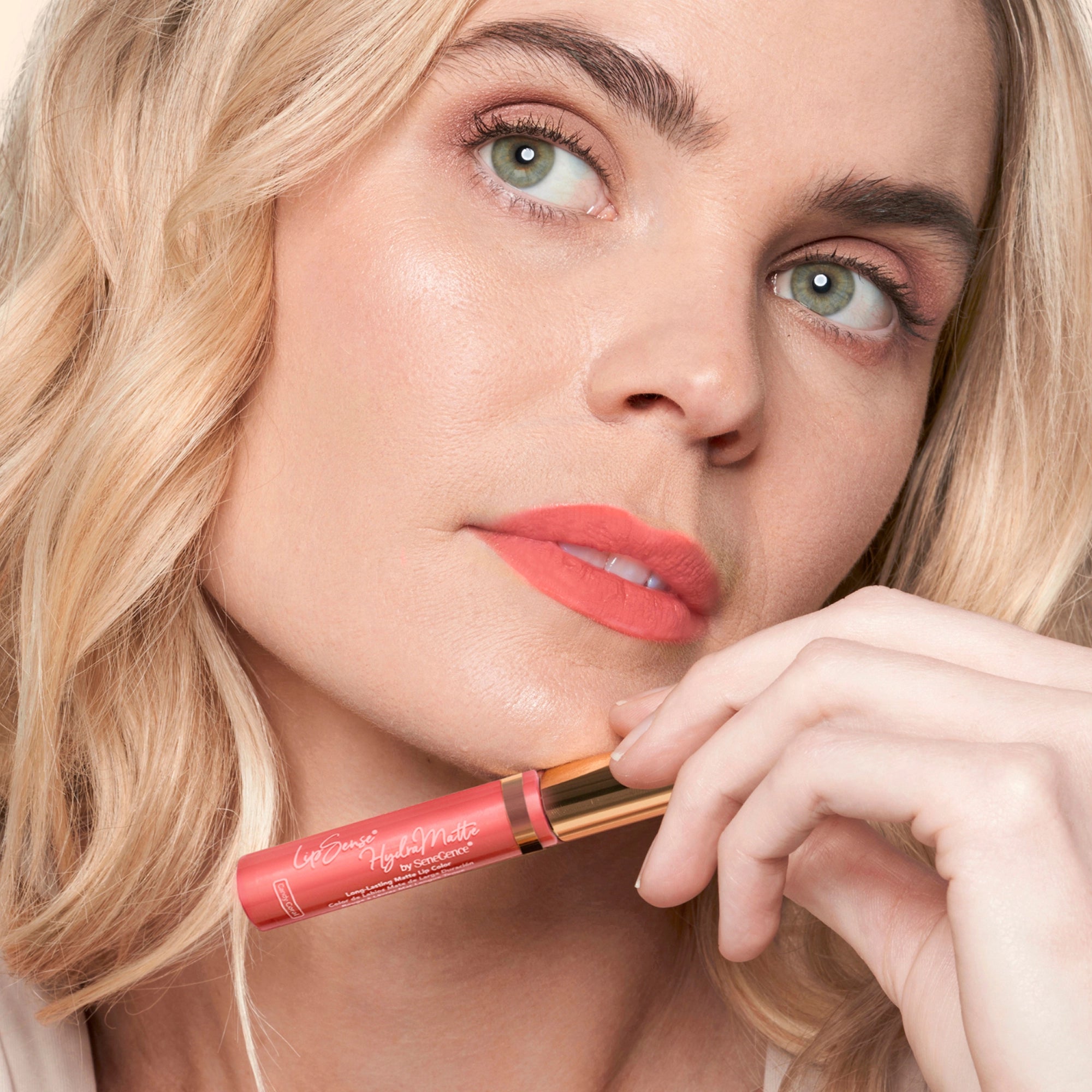 Model wearing LipSense Cream product shade Candy Coral.