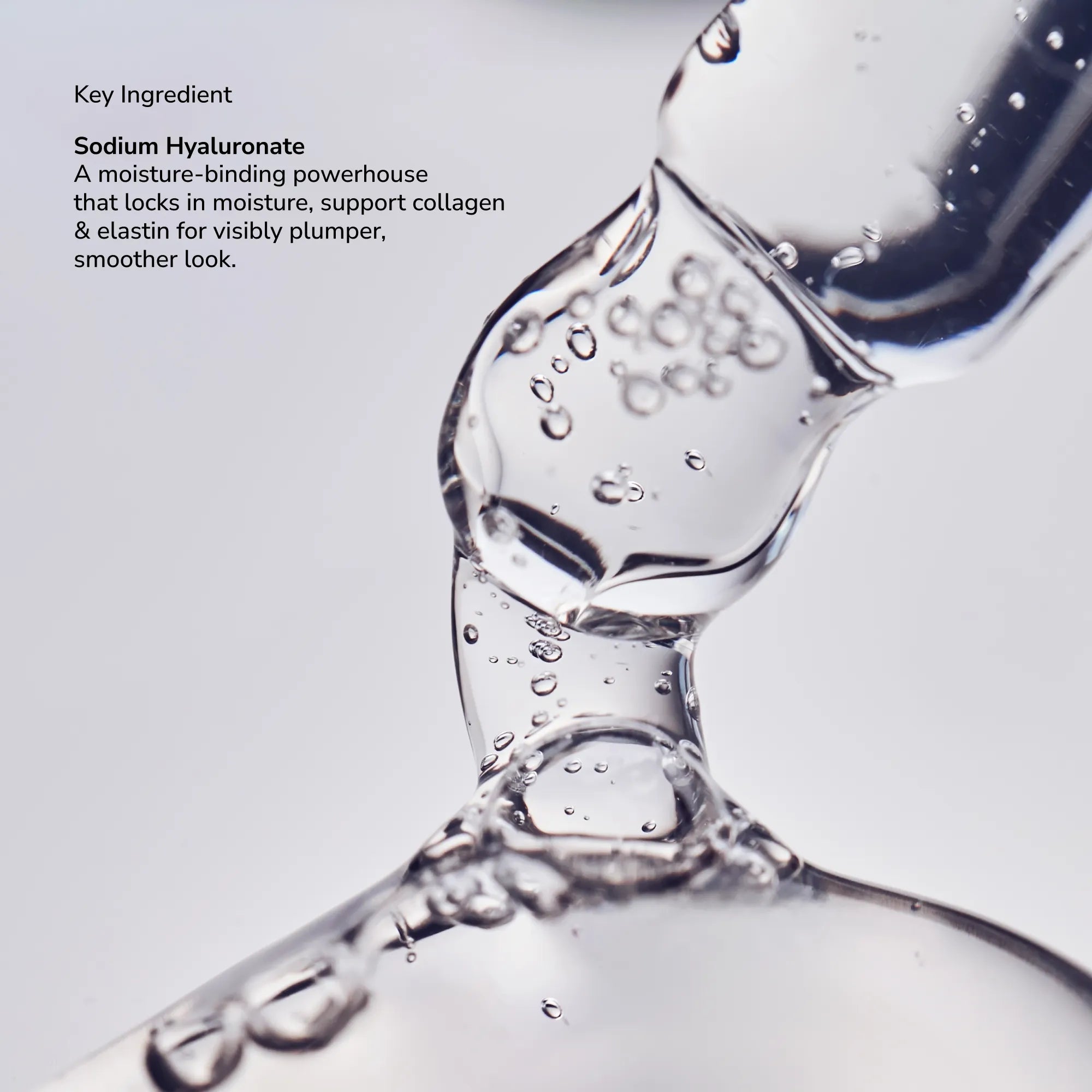 Close up of a stream of clear liquid with bubbles against a light background highlighting Sodium Hyaluronate as the key ingredient