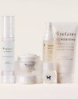 SeneGence Microbiome regimen set with four white skincare products arranged on a neutral backdrop